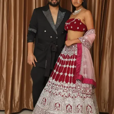 Here I am with a model wearing a beautiful bridal lehenga. The design features a rich velvet blouse paired with a heavily embroidered skirt in red and silver.