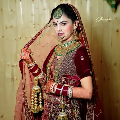 A stunning full-length portrait of a bride in her magnificent red velvet lehenga, showcasing the traditional kalire. I make sure to capture the entire bridal look in its full glory.
