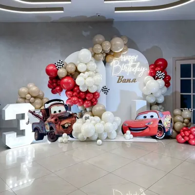 A dynamic Disney Cars themed birthday party for a 3-year-old. The setup includes large cutouts of Lightning McQueen and Mater, a marquee number "3", and a clean, modern backdrop.