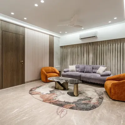 This living room is a masterclass in using color. We paired a soft lilac sofa with bold, burnt-orange swivel chairs to create a warm and inviting space, grounded by an abstract rug and Italian marble flooring.