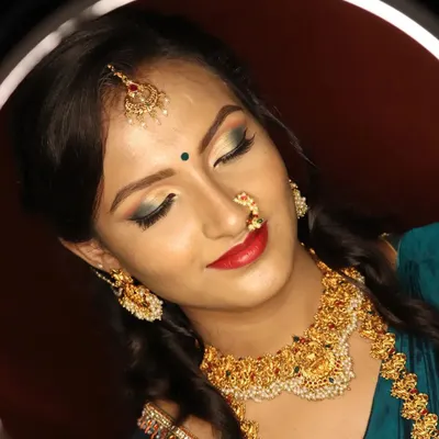 A close-up of a festive makeup look framed by a ring light. We focus on creating a flawless base, defining the eyes with a touch of color, and choosing the right lip shade to complete the traditional South Indian aesthetic.