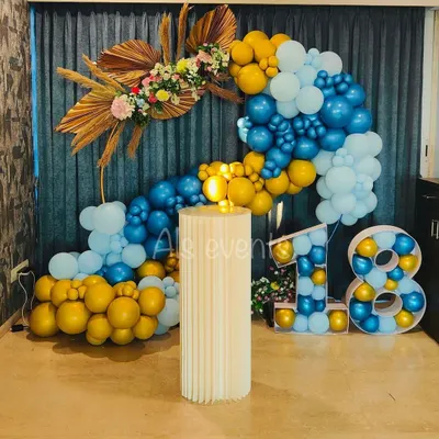 Here is a look at a stylish 18th birthday party we decorated. This setup features a modern balloon arch in shades of blue and gold, dried floral accents, and large marquee numbers to mark the special milestone.