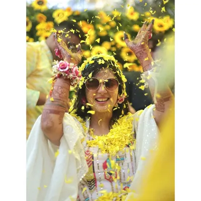 Pure joy and celebration! This bride is showered with yellow flower petals during her Haldi ceremony, and her happy, carefree expression says it all. These are the candid moments I love.
