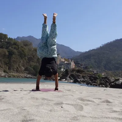 Yoga on the beach. A handstand on the sand in Rishikesh, feeling the energy of the earth and the sky.