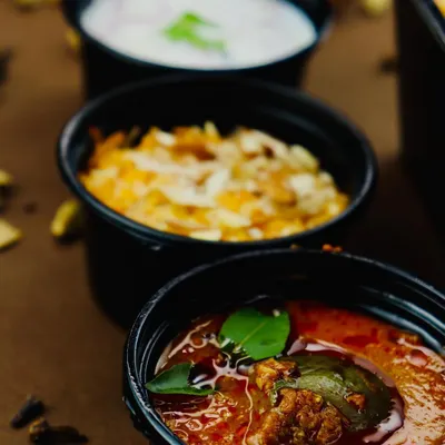 The perfect biryani trio: our tangy Baigan ka Khatta (brinjal gravy), creamy raita, and a sweet Gajar ka Halwa (carrot halwa). These sides are crafted to perfectly complement our main courses.