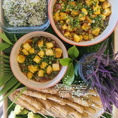 An Asian-inspired meal featuring Ginger Capsicum Fried Rice, Tofu in Black Bean Sauce, and crispy Baby Corn Skewers.
