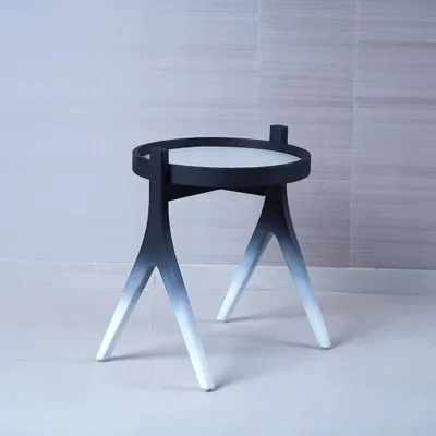 We designed this side table to be a piece of functional sculpture, featuring a striking black-to-white gradient on its tripod legs. Its minimalist form and unique finish make it a modern accent piece that adds an artistic touch to a space.