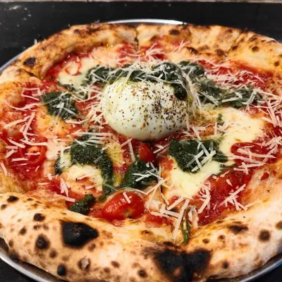 My signature Burrata Pesto Pizza. A whole ball of fresh, creamy burrata is placed in the center after baking, creating an amazing contrast with the hot pizza, savory pesto, and tangy tomato sauce.