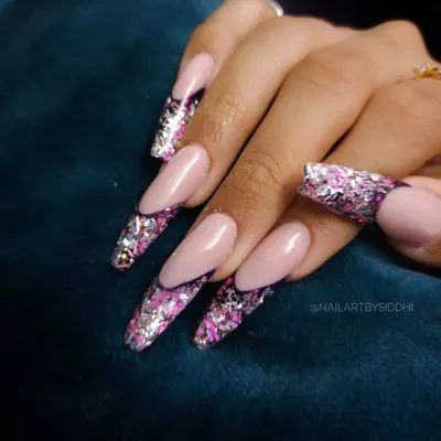 A dramatic and glamorous look, these long nails feature a French-style design with tips made entirely of chunky, holographic pink and silver glitter.
