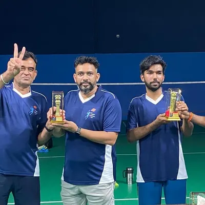 Three proud members of the winning team holding their well-deserved trophies.