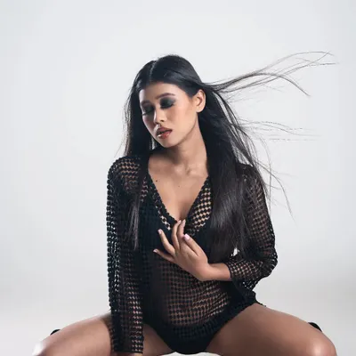 A powerful pose from a studio fashion shoot. The makeup features a dark, intense smoky eye and a contoured base, designed to look striking and last under professional studio lighting.