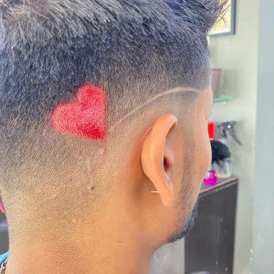 A close-up of a hair tattoo enhanced with color. I used an airbrush to create this vibrant red heart, adding a pop of color to the shaved design.