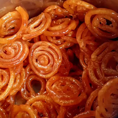 A close-up of our hot and crispy jalebis. I make them fresh to order, ensuring you get the perfect texture and sweetness every single time. A must-have for any celebration.