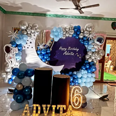 A stunning outer space theme for Advita's 6th birthday, with a crescent moon backdrop and a blue and silver balloon galaxy.