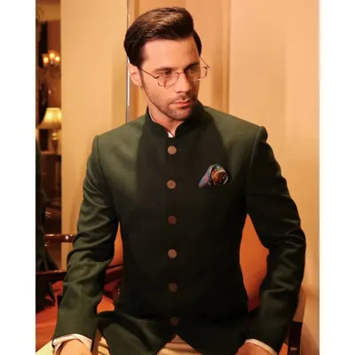 A perfect example of our Indo-Western style. This dark green bandhgala jacket, paired with light trousers, is finished with unique buttons made from antique 1 Anna coins.