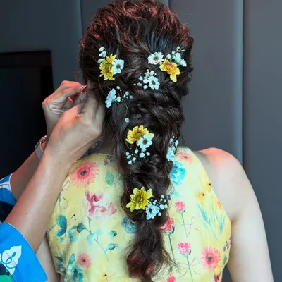 This Haldi bride’s messy fishtail braid is woven with fresh yellow and white flowers, creating a look of effortless, sun-kissed beauty.