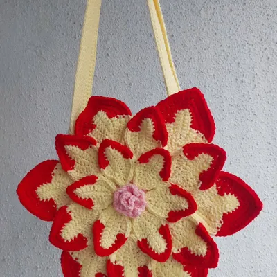 A clean, simple shot of the Lotus Bag, highlighting its intricate, layered petal design in red, yellow, and pink.