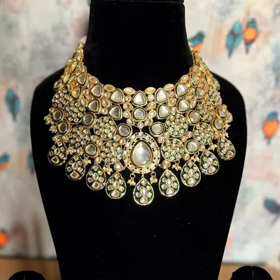 This royal extravagant Kundan jewelry piece is designed to be the centerpiece of your bridal look. Its intricate design and grand scale ensure a breathtaking appearance.