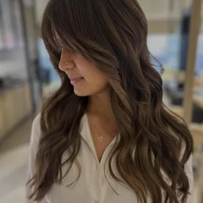 This client's first-ever hair color, and we did it without any bleach. The three-tone color and face-framing layers create a beautiful, subtle transformation.