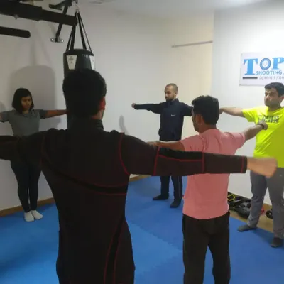 In this group session, I am guiding athletes through arm and shoulder exercises. These drills are crucial for developing the muscle memory and stability needed to hold a rifle or pistol steady without fatigue.