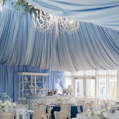 A wide-angle view showing the full effect of the draped ceiling, which created a soft, cloud-like canopy over the entire event. The crystal chandelier adds a touch of sparkle to this elegant baby welcome celebration.