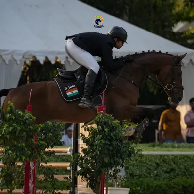 A moment of pure focus and athleticism. This shot captures the powerful partnership between horse and rider as they navigate a challenging course, a hallmark of our advanced show jumping program.