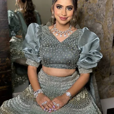 Sangeet glam goals. This bride-to-be is serving soft glam with a hint of sparkle in her stunning grey lehenga with dramatic puff sleeves.