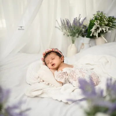 A tiny angel sleeping on a bed of white. This simple, light-filled setup creates a truly ethereal and timeless portrait.