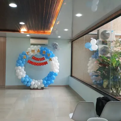 A classic blue and white circular balloon ring decoration for a birthday party. This simple yet elegant setup is perfect for photo opportunities and as a cake-cutting backdrop.
