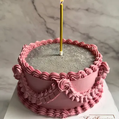 A vintage dream in pink and silver. This cake features classic Lambeth-style piping with delicate ruffles and a sparkling silver top, perfect for a truly special celebration.