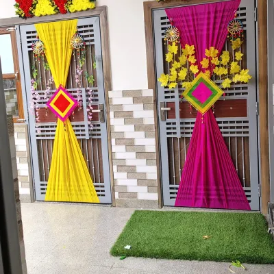 This is a popular choice for home-based wedding functions. I use bright, contrasting fabric drapes in colors like yellow and magenta to create a festive entrance, perfect for setting the mood for a Haldi or Mehendi ceremony.