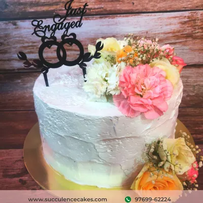 This "Just Engaged" cake features a rustic, textured frosting and a beautiful arrangement of fresh, colorful carnations and roses. It’s a perfect example of how I use natural elements to create a stunning, organic design.