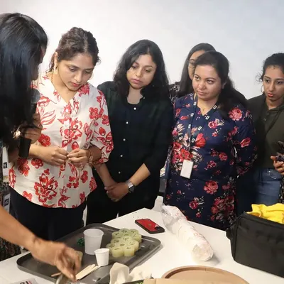 An instructor demonstrates the finer points of candle making to an attentive group during a corporate workshop at HBC, Bangalore. We provide close guidance to ensure everyone understands the process.