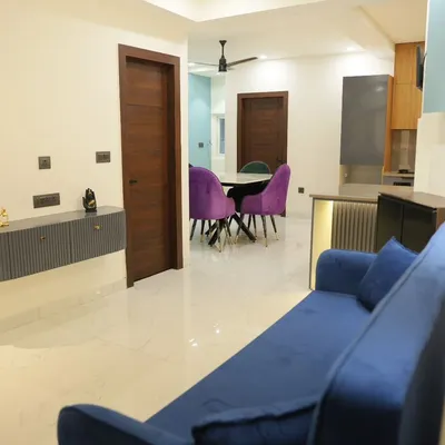 This view shows how the living and dining areas connect in an open-plan layout. The vibrant purple chairs add a pop of color, while the floating console keeps the entryway feeling spacious.