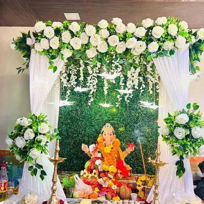A full view of my popular modern Ganpati decor. The combination of a green wall, soft white fabrics, and classic white roses provides a clean, elegant look that highlights the idol beautifully.