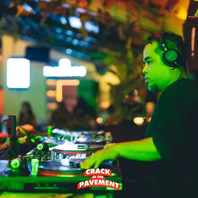 Locked in during a set. The green light, the focus, the crowd in the background, this is the essence of a live performance.