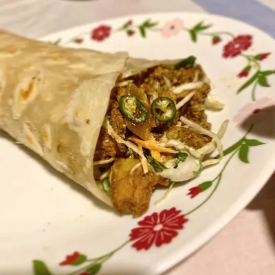 Introducing the Kodava Chilly Pork Kathi Roll. We wrap our zesty chilly pork in a soft flatbread with a crunchy slaw, a squeeze of lemon, and fresh green chilies for a spicy, tangy, and satisfying meal on the go.