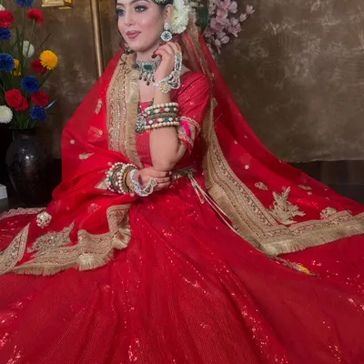 A stunning Muslim bride look in a classic red sequin lehenga. The highlight is the green beaded jewellery set, including a passa, choker, and layered necklace, creating a beautiful color contrast.