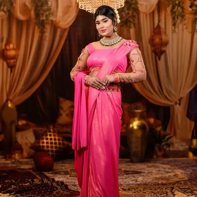 A stunning full-length view of our Shantipriya recreation. The shimmering pink saree, elegant drape, and grand chandelier in the background come together to create a look of pure vintage Bollywood glamour.