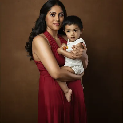 A mother's love, captured in a timeless frame. This classic portrait against a painterly brown backdrop has the feel of an old master's painting, elegant and everlasting.