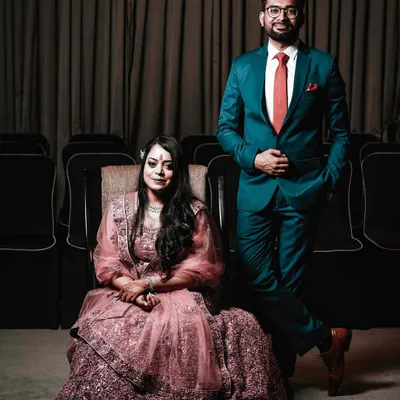 A classic and elegant portrait from an engagement ceremony. The couple poses with poise and confidence, showcasing their stylish formal wear and the celebratory atmosphere of the event.