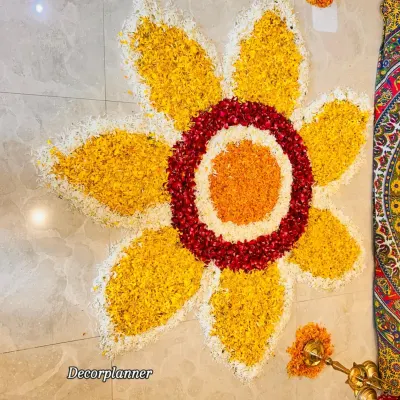 A top-down view of a large flower rangoli I designed for an Annaprashan ceremony. The vibrant colors of marigold, rose, and chrysanthemum petals create a stunning pattern on the floor.