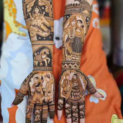 This is a full view of a bridal mehndi set, with each arm telling a different part of the story. One arm features a doli scene, while the other shows a divine couple, creating a rich narrative for the bride.