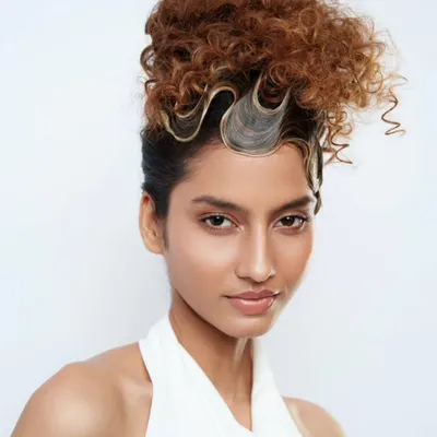 An artistic updo from the Schwarzkopf Professional "Lived-In Show," combining defined curls with sculpted waves for a high-fashion statement.