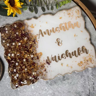 A simple and elegant nameplate made with a couple's preserved wedding garland. The white resin and gold lettering create a classic look for their home.