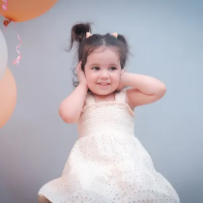 Officially two and still stealing hearts! This little girl's personality shines in her second birthday portrait, complete with a cute dress and pigtails.