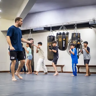 A full line of students practicing their boxing stance and punches. Led by pro fighter Seth Rosario, this class focuses on repetition and proper form to build muscle memory for effective striking.