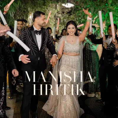 A grand entrance for a grand night. The couple walks in, hand in hand, through a tunnel of light sticks held by their cheering friends and family.