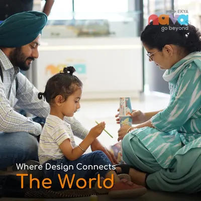 A family is captured in a moment of creative collaboration on the floor of our campus, with the words "Where Design Connects The World." This image embodies our belief in learning through connection and hands-on design.