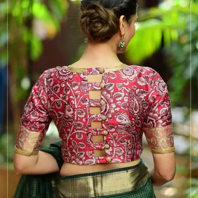 This red printed blouse features a unique buttoned-up ladder design on the back, offering a modern twist on a traditional pattern.